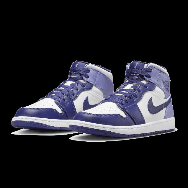 Paarse Nike Air Jordan 1 Mid Blueberry sneakers op groene achtergrond