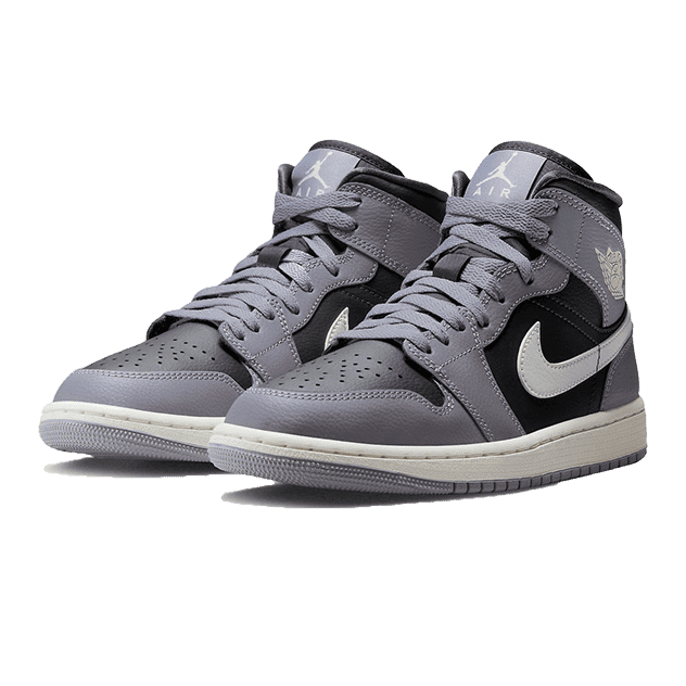 Grijze Nike Air Jordan 1 Mid Cement sneakers op een groene achtergrond