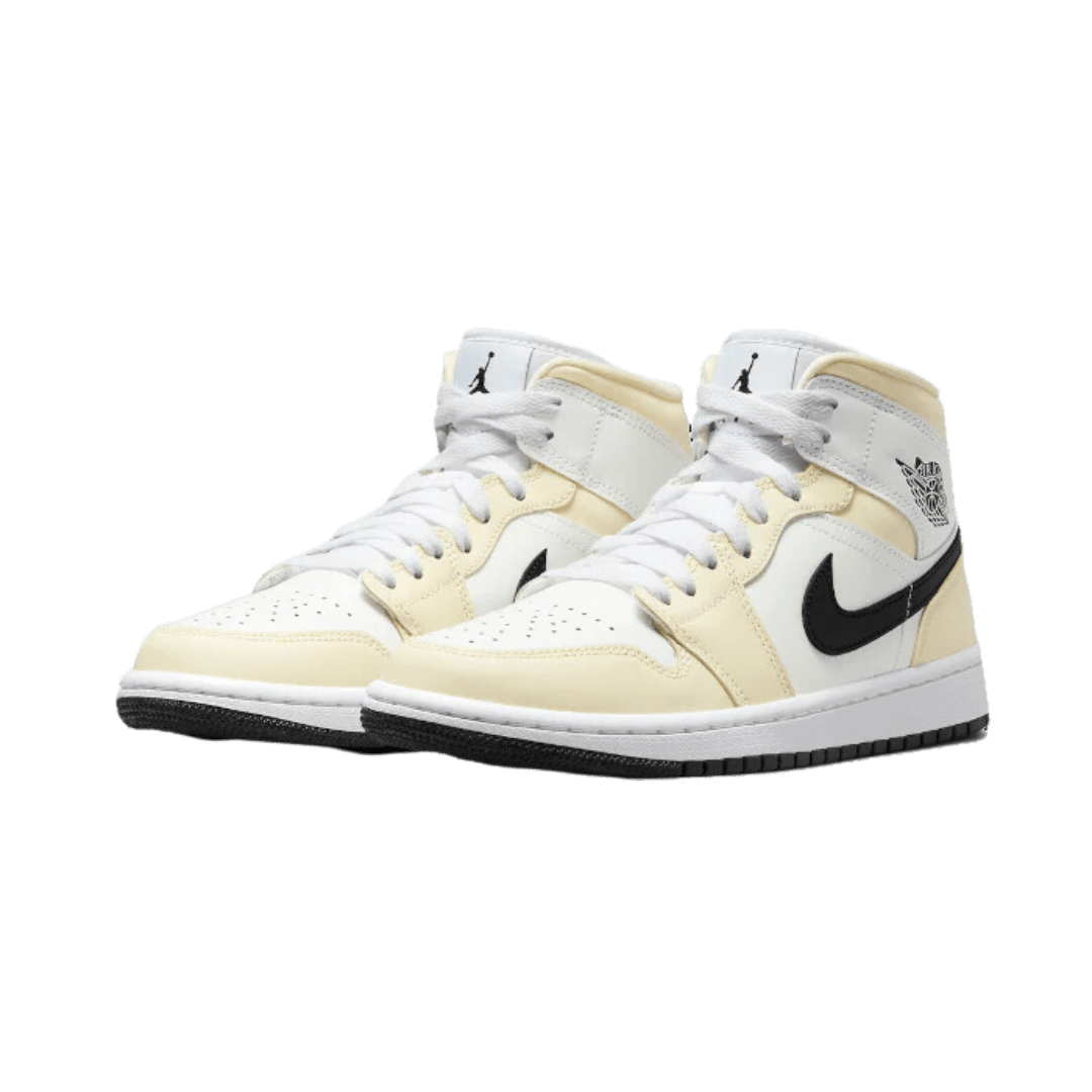 Prachtige Air Jordan 1 Mid Coconut Milk sneakers in wit en geel, geplaatst op een effen groene achtergrond. Deze klassieke basketbalschoenen hebben een modern, elegant ontwerp met fijne details zoals de logo's van Nike en Jordan. Een fashionable item voor iedere sneakerliefhebber.