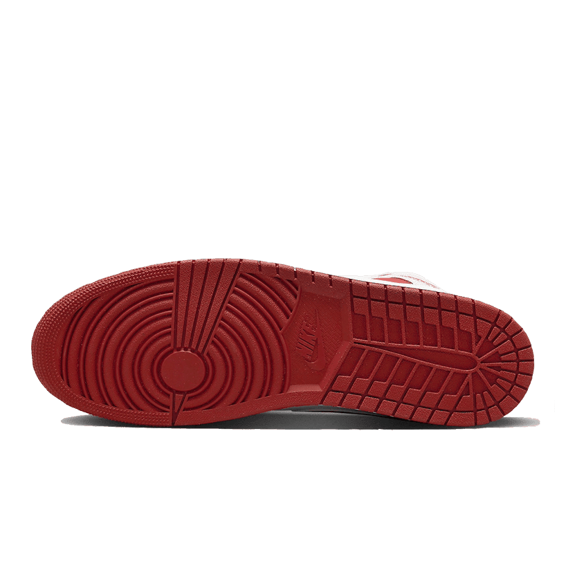 Rode Air Jordan 1 Mid Dune sneakers met opvallende zooldetails op een groene achtergrond