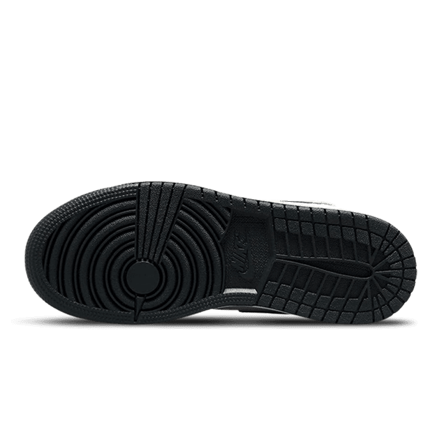 Zwarte Air Jordan 1 Mid Dunk Contest sneakers met uniek zwart rubberen zoolprofilering op een groene achtergrond