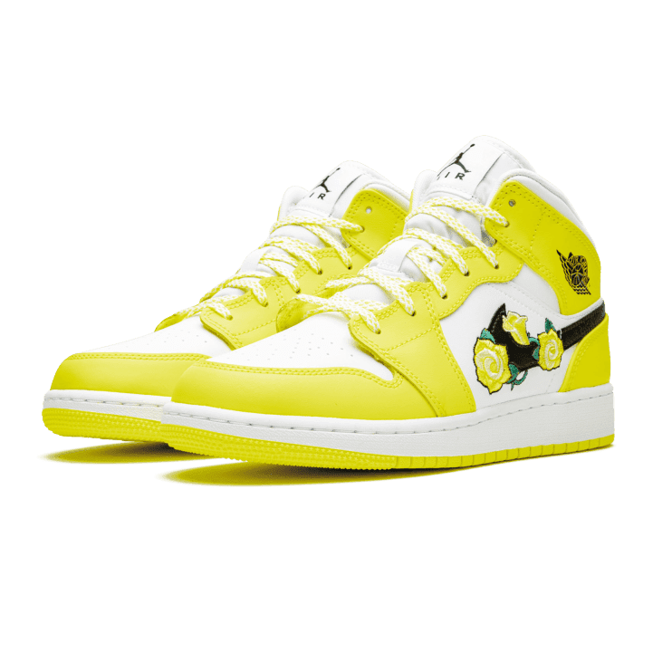 Heldere gele Air Jordan 1 Mid Dynamic Yellow sneakers met witte details en zool op een groene achtergrond