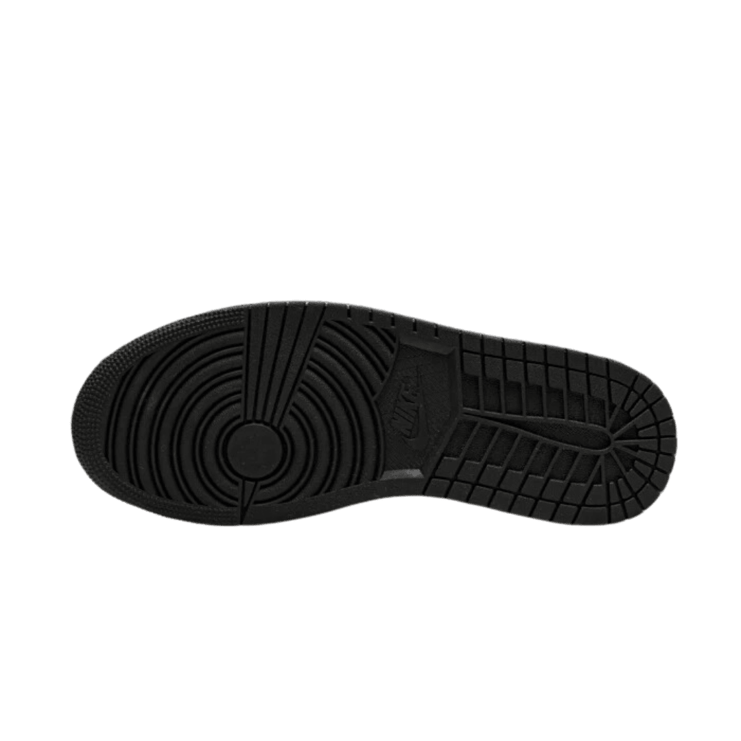 Zwarte Nike Air Jordan 1 Mid Earthy Brown sneakers met een geribbelde profielzool op een groene achtergrond