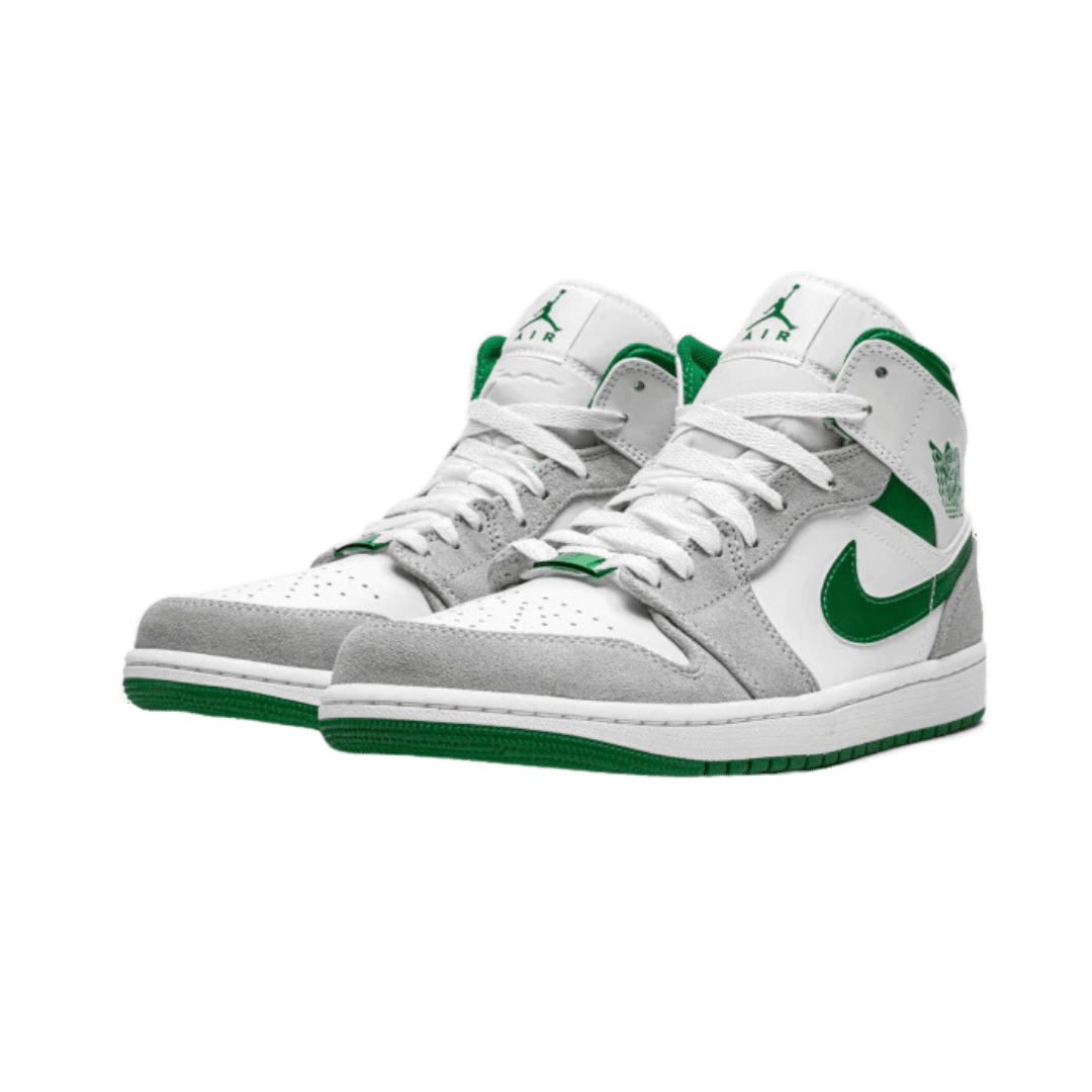 Grijs-groene Nike Air Jordan 1 Mid sneakers op een effen groene achtergrond