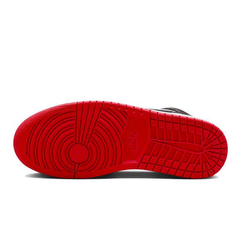 Rode Nike Air Jordan 1 Mid sneakers met een zwart kunstleren bovendeel en rood rubberen zool, op een effen groene achtergrond.