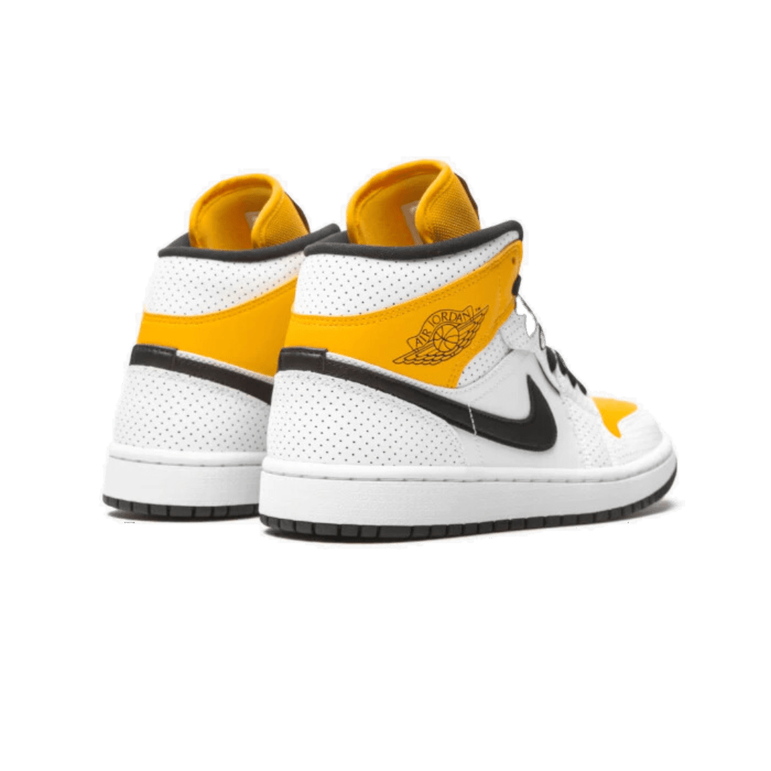 De Nike Air Jordan 1 Mid Laser Orange sneakers, met hun witte bovenwerk, oranje accenten en zwarte details, zijn prominent in beeld tegen een groene achtergrond. Deze iconische basketbalschoenen bieden stijl en comfort voor de moderne stedelijke mode.