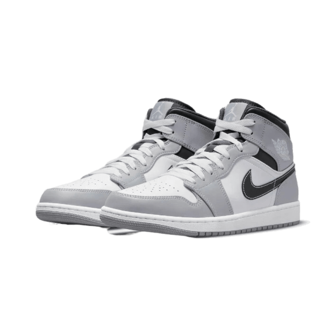 Paartje Nike Air Jordan 1 Mid Light Smoke Grey Anthracite sneakers op effen groene achtergrond