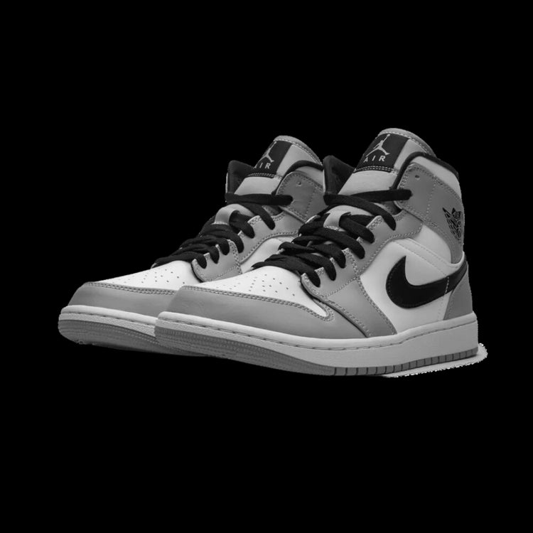Klassieke lichtgrijze Nike Air Jordan 1 Mid-sneakers op een donkergroene achtergrond