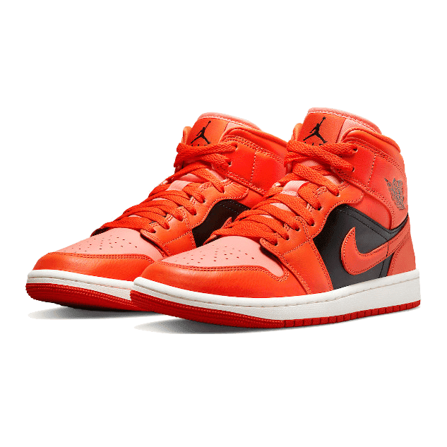 Oranje-zwarte Nike Air Jordan 1 Mid sneakers tegen een groene achtergrond