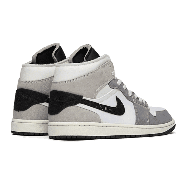 Grijze Nike Air Jordan 1 Mid SE Craft sneakers op een groen oppervlak