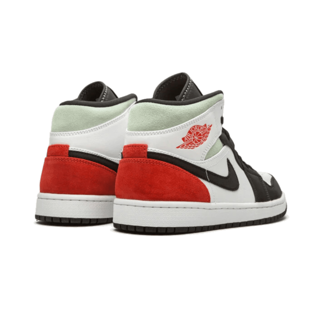 Elegant Nike Air Jordan 1 Mid SE Union Black Toe sneakers op een groene achtergrond. Deze exclusieve schoenen hebben een wit, zwart en rood kleurenschema met een opvallend Union-logo. Een must-have item voor elke sneakerfan.