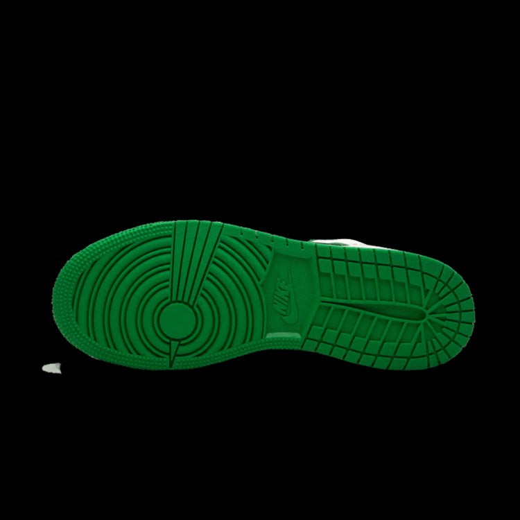 Groene sneakerzooltje met opvallend grippatroon op een groen oppervlak