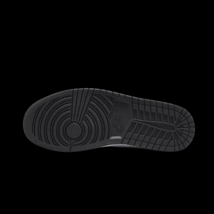 Zwarte Air Jordan 1 Mid SE Zen Master sneakers tegen een groene achtergrond. Het kenmerkende Nike Air logo op de rubberen zool is duidelijk zichtbaar.