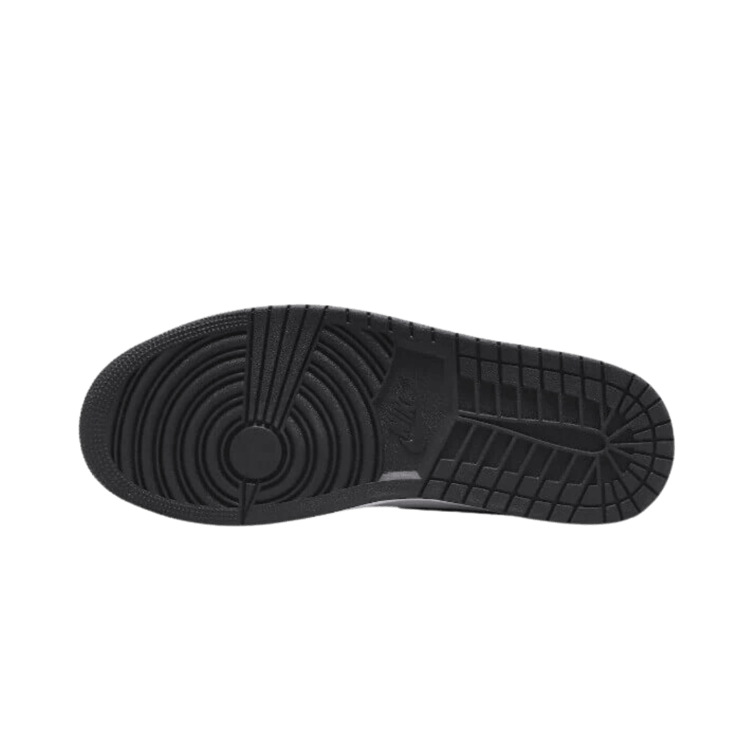 Zwarte Air Jordan 1 Mid SE Zen Master sneakers tegen een groene achtergrond. Het kenmerkende Nike Air logo op de rubberen zool is duidelijk zichtbaar.