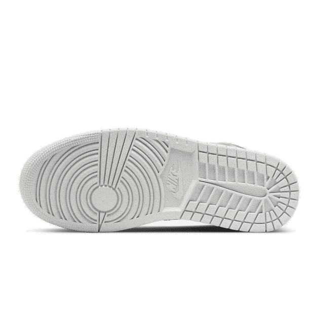 Beige Nike Air Jordan 1 Mid Sanddrift sneakers met een gedetailleerde zool op een groene achtergrond