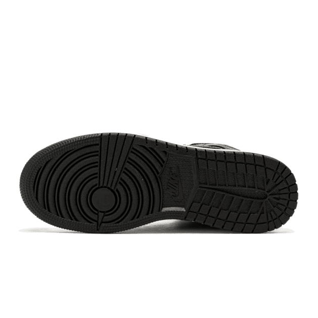 Zwarte Nike Air Jordan 1 Mid Shadow Red sneakers op een groene achtergrond