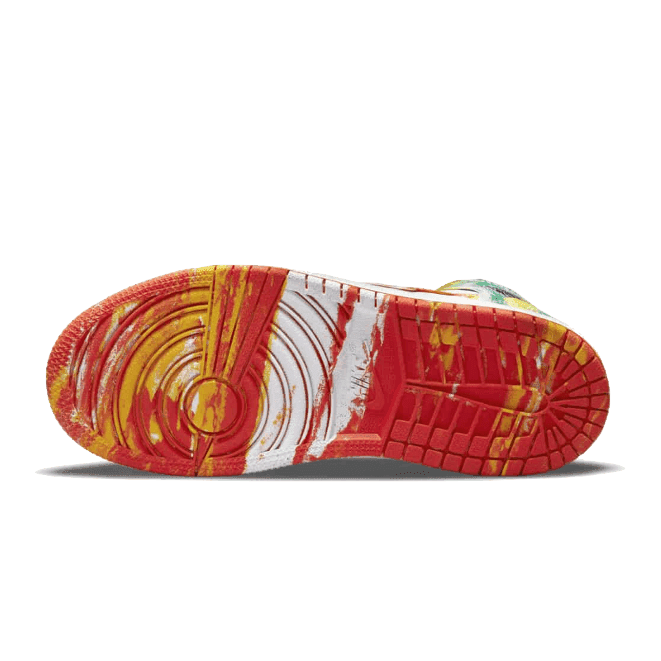 Rode en gele sneaker Air Jordan 1 Mid Slim Vortex van Nike met een opvallende, gelaagde zool op een groene achtergrond.