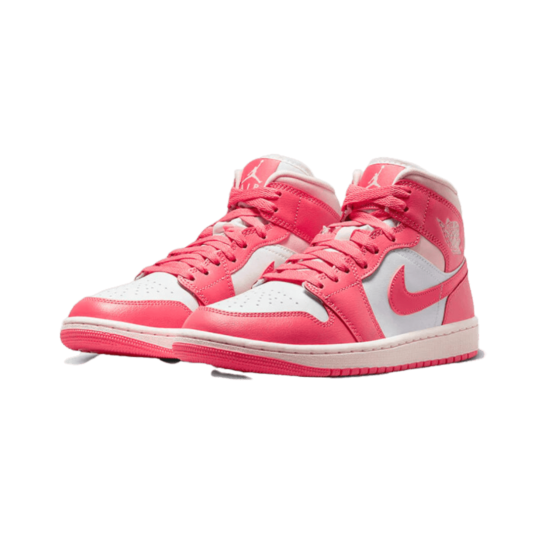 Roze en witte Air Jordan 1 Mid sneakers met 'Strawberries and Cream'-stijldetails, geplaatst op een groene achtergrond.