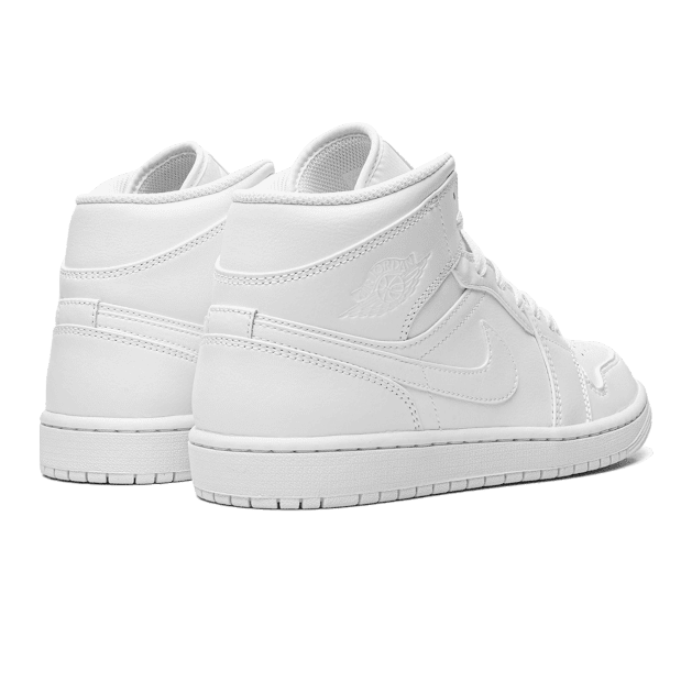 Witte Nike Air Jordan 1 Mid sneakers op een groene achtergrond. De sneakers hebben een eenvoudig, minimalistisch design en zijn gemaakt van hoogwaardig materiaal. Deze iconische sneaker is een klassieker binnen de streetwear mode.