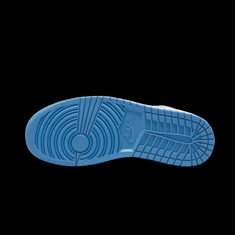 Blauwe, gestructureerde zool van Nike Air Jordan 1 Mid True Blue schoen op groene achtergrond