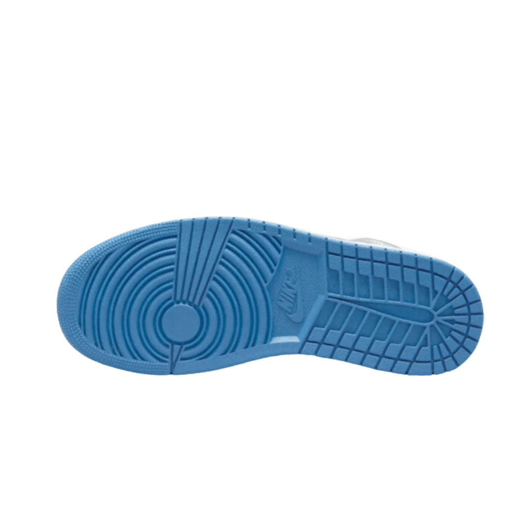Blauwe, gestructureerde zool van Nike Air Jordan 1 Mid True Blue schoen op groene achtergrond