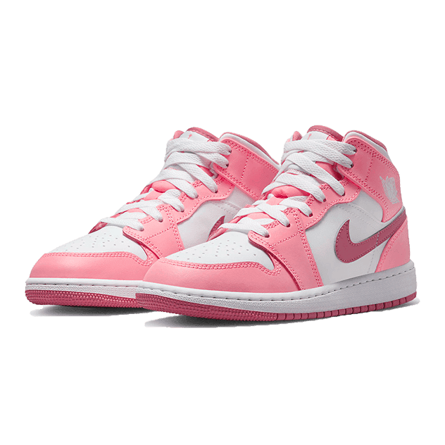 Roze en witte Air Jordan 1 Mid Valentine's Day sneakers op een groene achtergrond