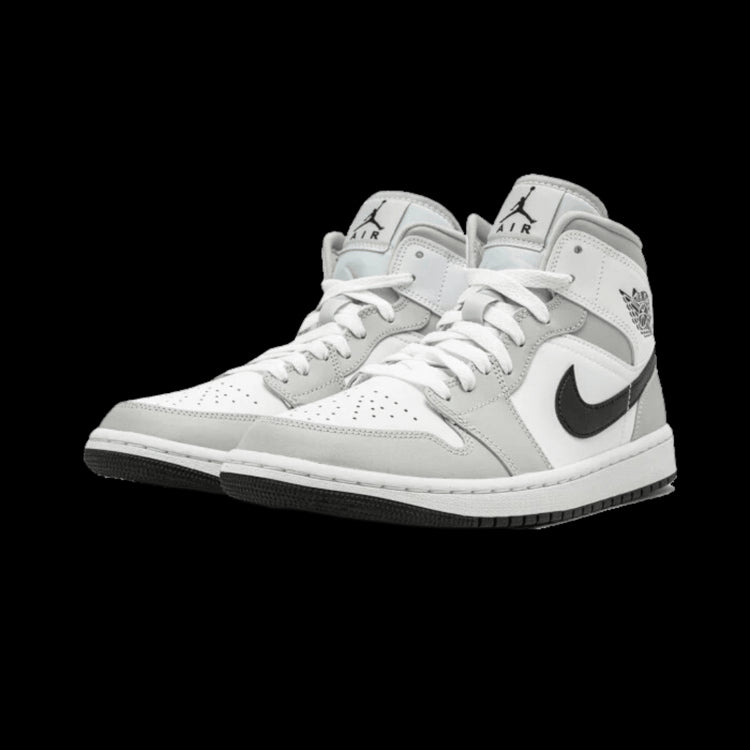 Elegante Air Jordan 1 Mid sneakers in licht grijze kleurstelling. De klassieke basketbalschoenen met kenmerkend Nike swoosh-logo en voorzien van stevige zool.