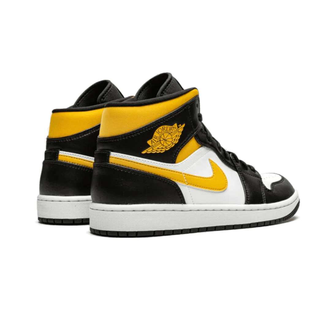 Stijlvolle Air Jordan 1 Mid sneakers in zwart, geel en wit. Het opvallende ontwerp met gele accenten en het bekende Nike-logo maken deze schoenen tot een must-have accessoire. Perfect voor modebewuste sneakerliefhebbers.
