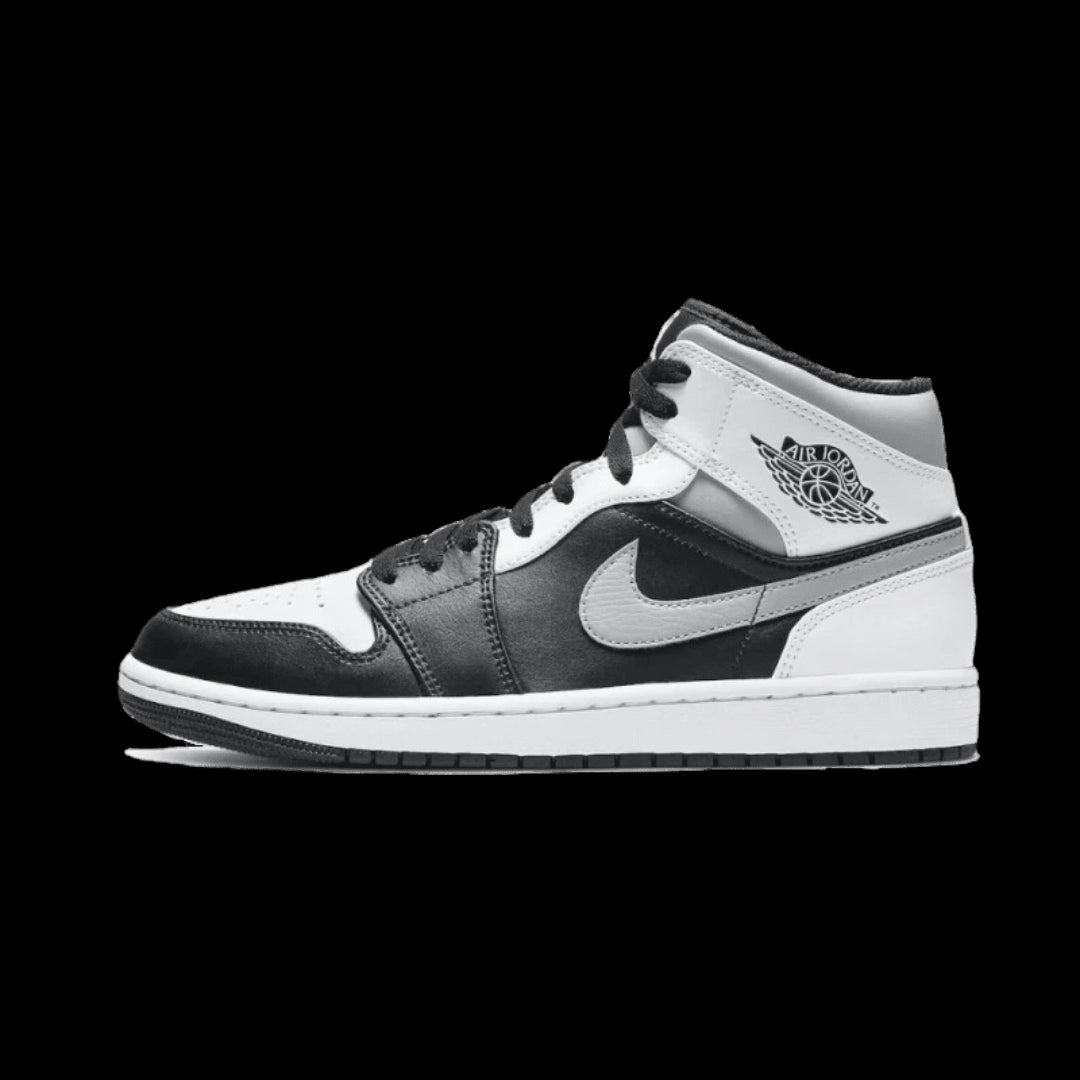 Klassieke Air Jordan 1 Mid sneakers in wit en zwart. Een iconisch Nike-ontwerp met premium materialen en detail. Deze sneakers zijn perfecte toevoegingen aan je garderobe.