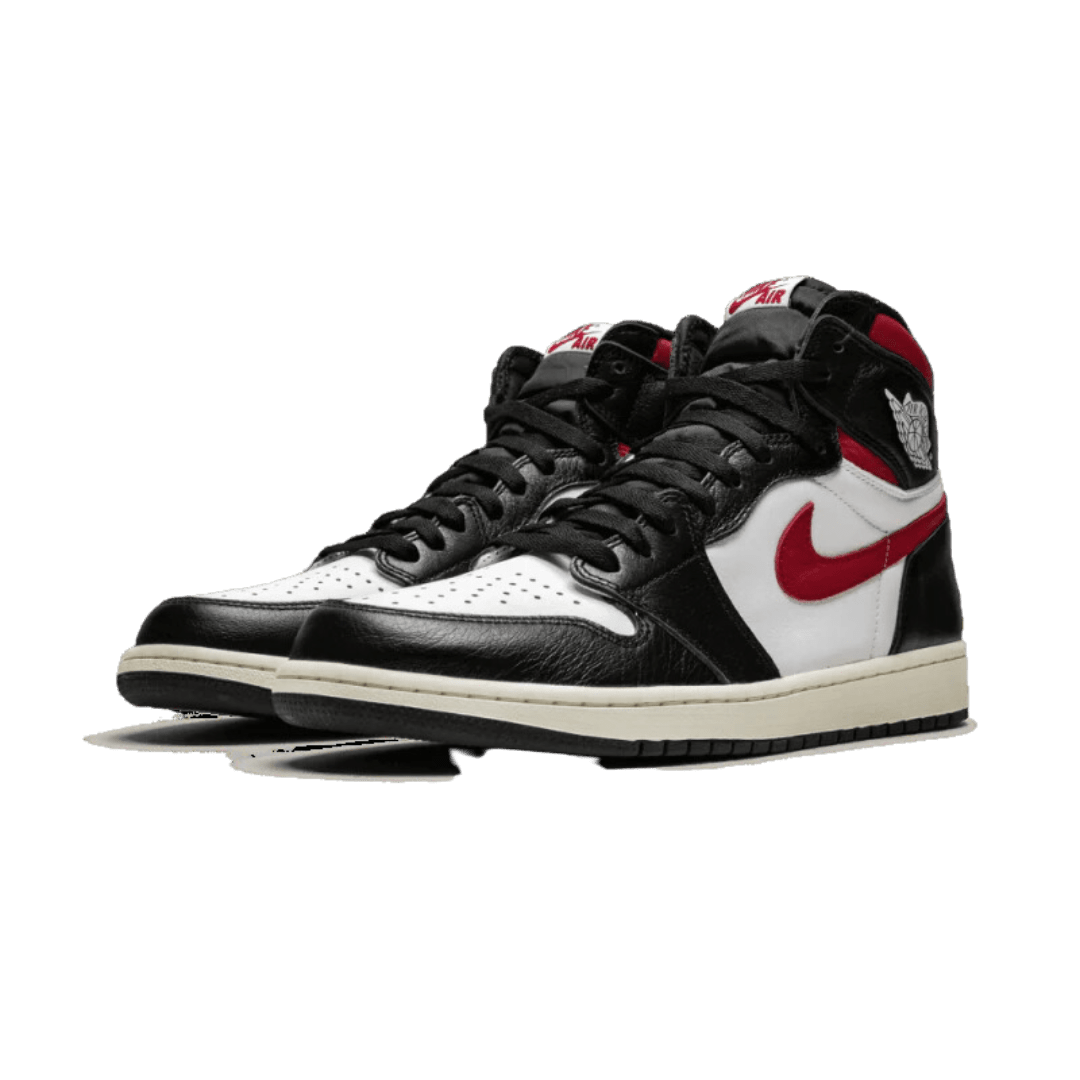 Zwarte en rode Nike Air Jordan 1 Retro High sneakers op een groene achtergrond