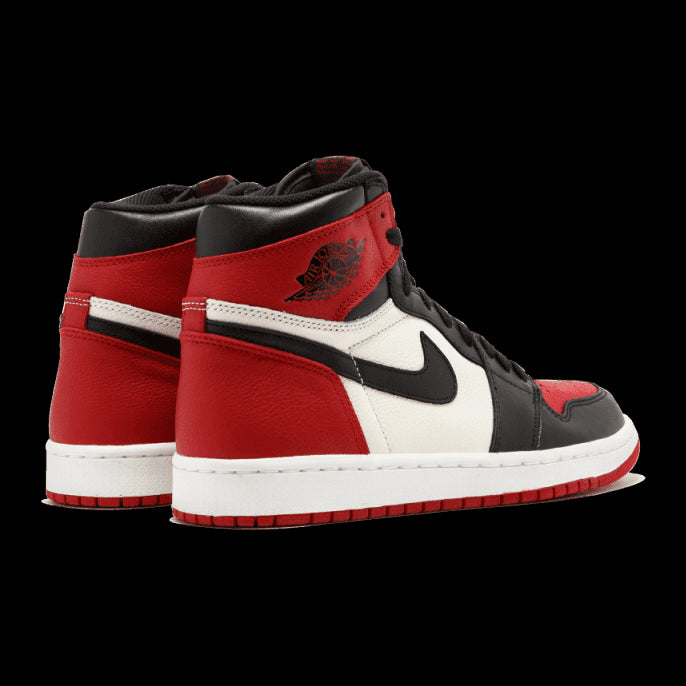 Elegante sneakers Air Jordan 1 Retro High Bred Toe in rode en zwarte kleuren, met het Nike-logo op de zijkant. De schoen heeft een klassiek basketbaldesign met een leren bovenwerk.