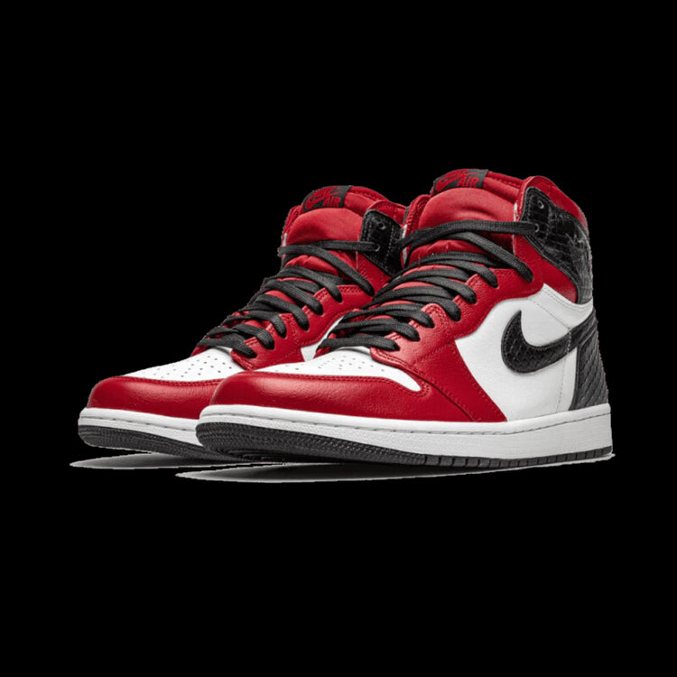 Rode en zwarte Nike Air Jordan 1 Retro High Satin Snake Chicago sneakers op een groene achtergrond