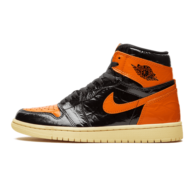 Exclusieve, oranje en zwarte Nike Air Jordan 1 Retro High sneakers op een groen oppervlak