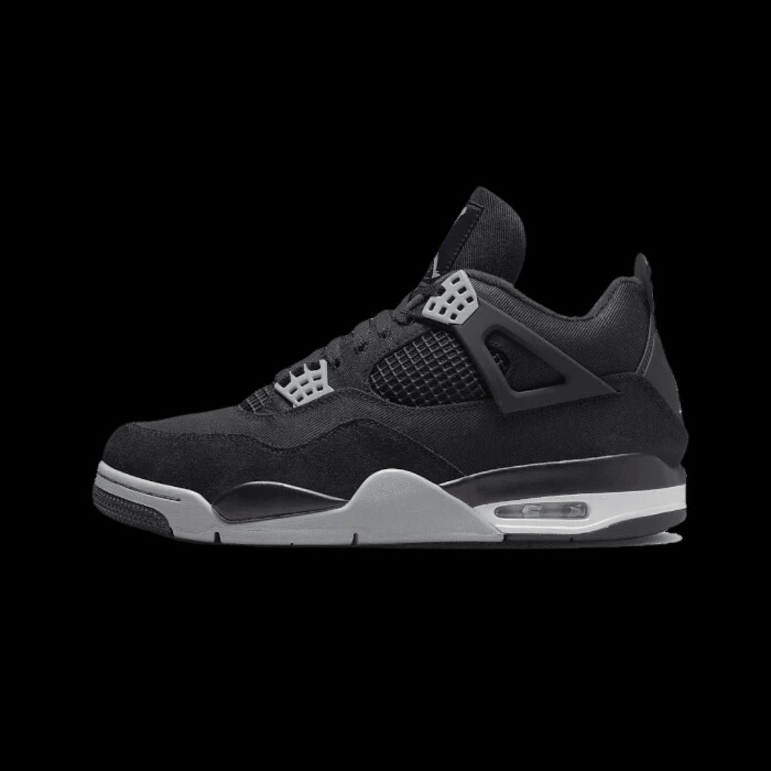Stijlvolle Air Jordan 4 Black Canvas sneakers in beeld geplaatst tegen een groene achtergrond. Deze sportieve schoenen van Nike hebben een zwart canvas bovenwerk en zijn voorzien van de kenmerkende Air Jordan details.