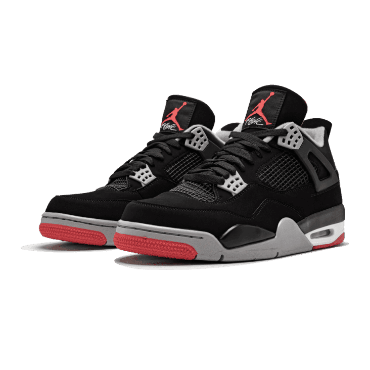 Zwarte Nike Air Jordan 4 Bred 2019-sneakers op een groene achtergrond. Deze klassieke basketbalschoenen hebben een zwart leren bovenwerk, wit en grijs accenten en een rode zool.