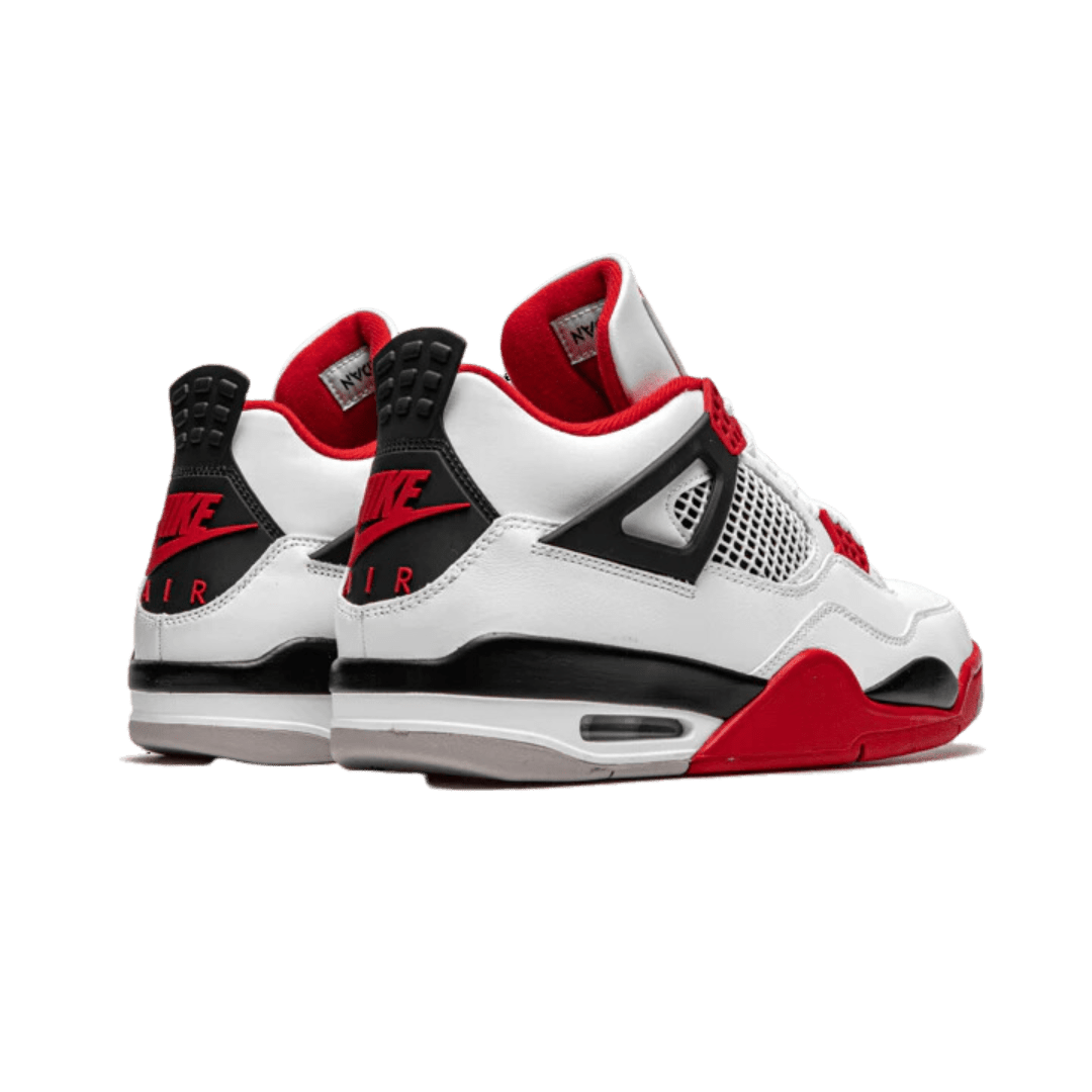 Witte, zwarte en rode Nike Air Jordan 4 Retro Fire Red (2020) sneakers tegen een groene achtergrond geplaatst