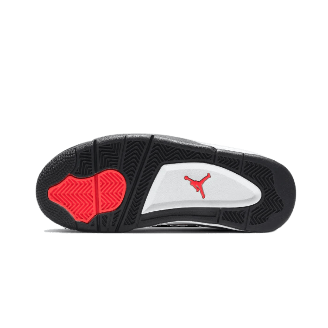Zwart en wit sportieve sneaker met rode details van het Nike Air Jordan 4-model, op effen groene achtergrond