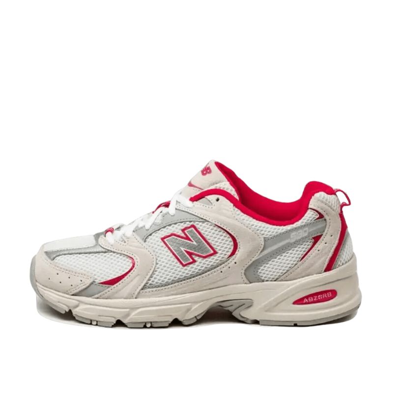 Klassieke New Balance 530 sneakers in beige en rood. De schoen heeft een sportieve look met luchtinlaat voor ventilatie. Het bekende N-logo in rood geeft het model een stijlvol accent. Deze veelzijdige sneakers zijn perfect voor een actieve levensstijl.