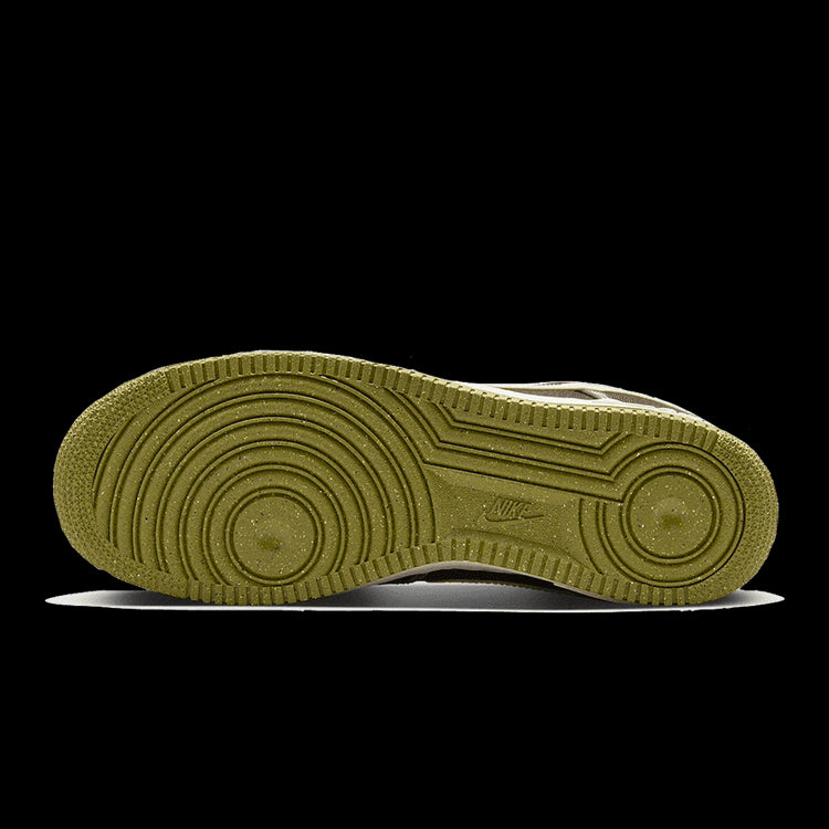 Bruin lederen Nike Air Force 1 '07 PRM sneaker met een ruitprofielzool op een groene achtergrond