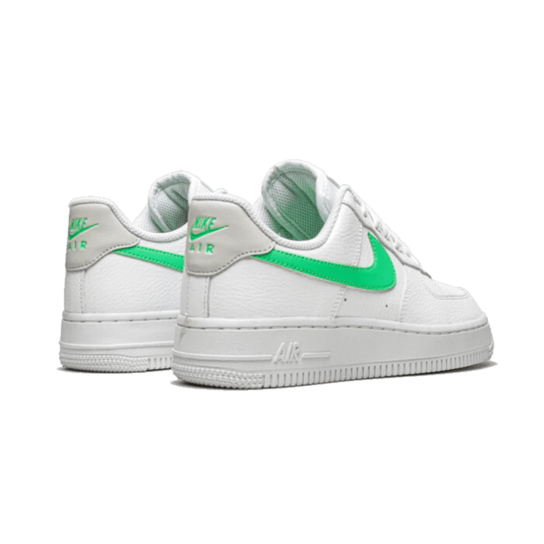 Witte Nike Air Force 1 Low '07 sneakers met groene accenten. Deze klassieker heeft de bekende Nike Air technologie en biedt comfort en stijl voor dagelijks gebruik.