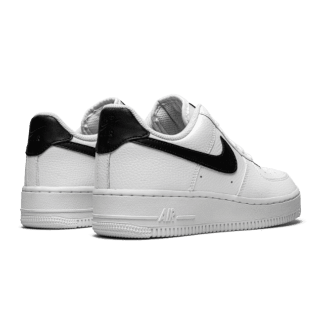 Witte Nike Air Force 1 Low '07 sneakers op effen groene achtergrond