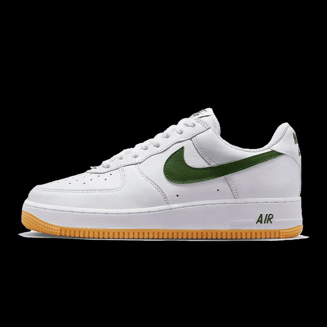Gestroomlijnde witte Nike Air Force 1 Low sneakers met groen Swoosh-logo, ontworpen voor stijl en comfort.