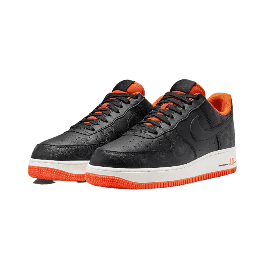 Nike Air Force 1 Low Halloween (2021) sneakers op een zwarte en oranje kleurschema met een groene achtergrond.