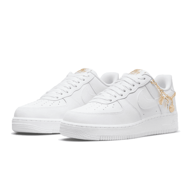 Witte Nike Air Force 1 Low LX Lucky Charms sneakers op een groene achtergrond