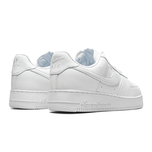 Witte Nike Air Force 1 Low NOCTA Drake Certified Lover Boy sneakers op een groene achtergrond