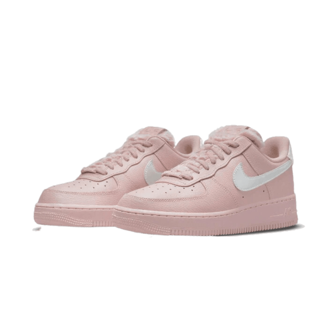 Roze Nike Air Force 1 Low sneakers op een effen groene achtergrond