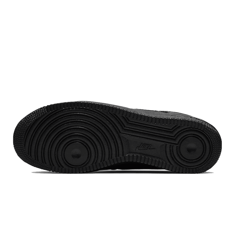 Stijlvolle Nike Air Force 1 Low QS sneakers in zwart-wit ontwerp op groene achtergrond.