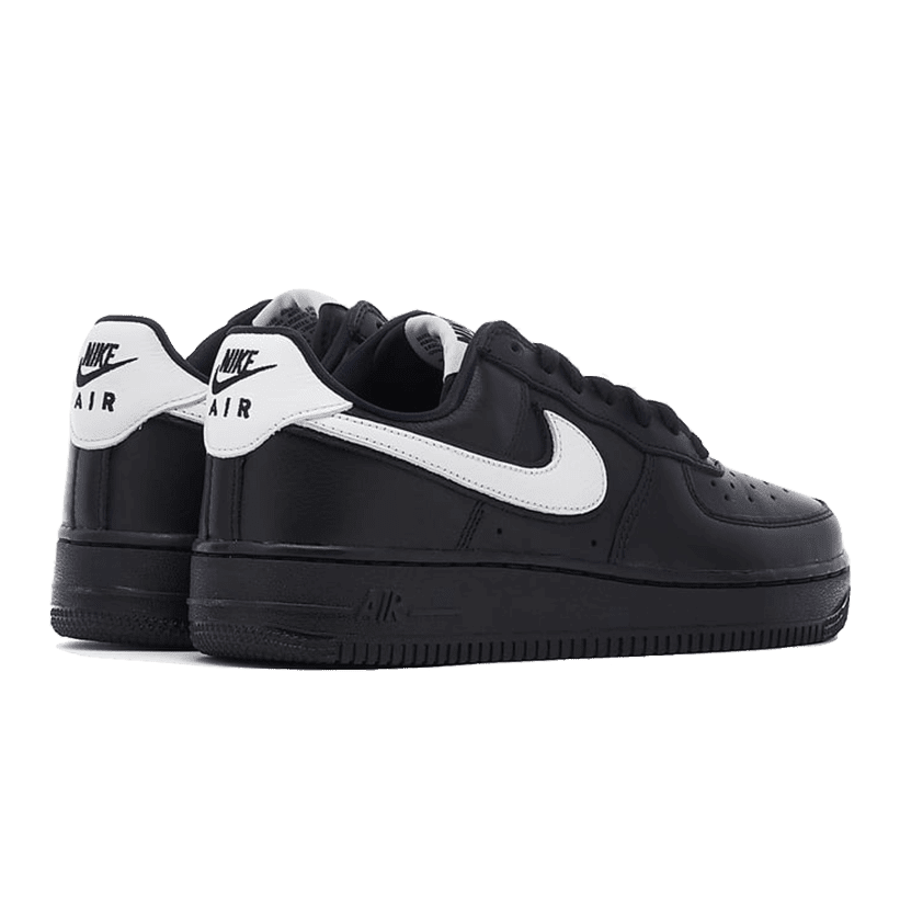 Zwarte Nike Air Force 1 Low QS sneakers op effen groene achtergrond