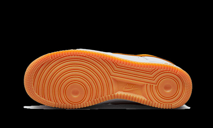 Oranje rubberen zool met karakteristieke Nike-structuur op Nike Air Force 1 Low Retro University Gold sneaker