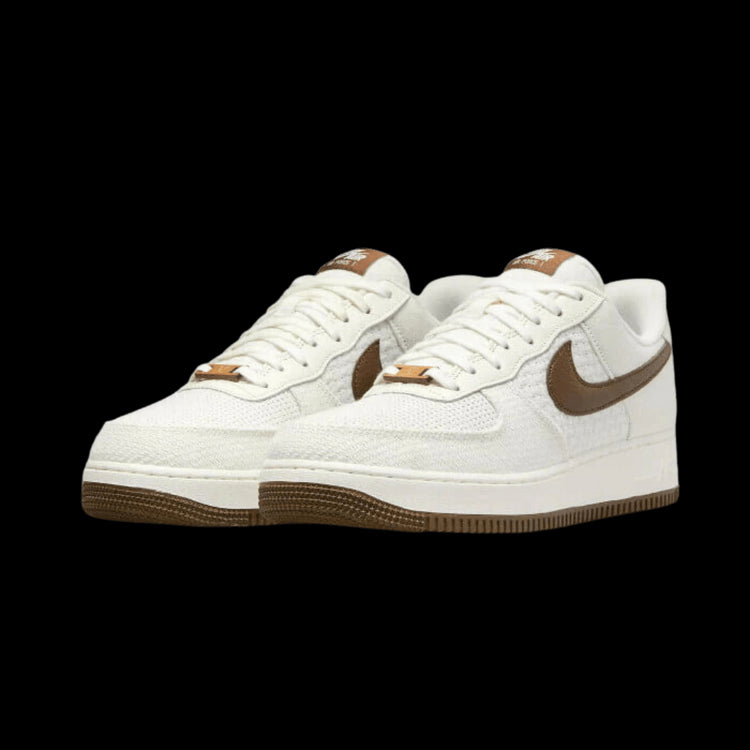 Witte leren Nike Air Force 1 Low SNKRS Day 5th Anniversary sneakers op een groene achtergrond.